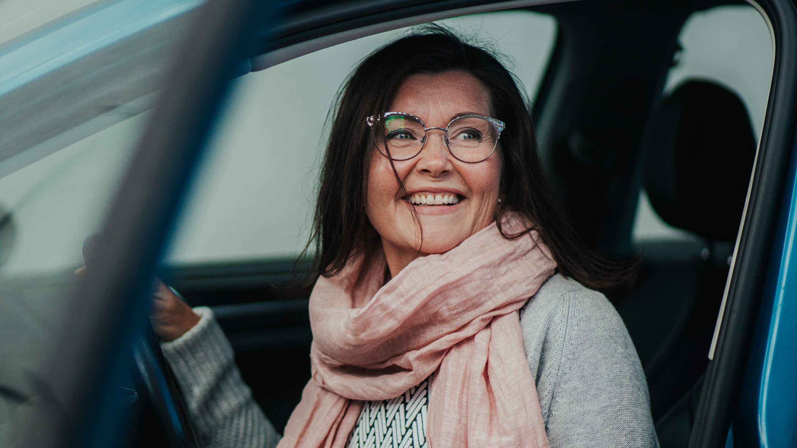 Ajonäkö korjattuna silmälasit päässä autossa istuva nainen